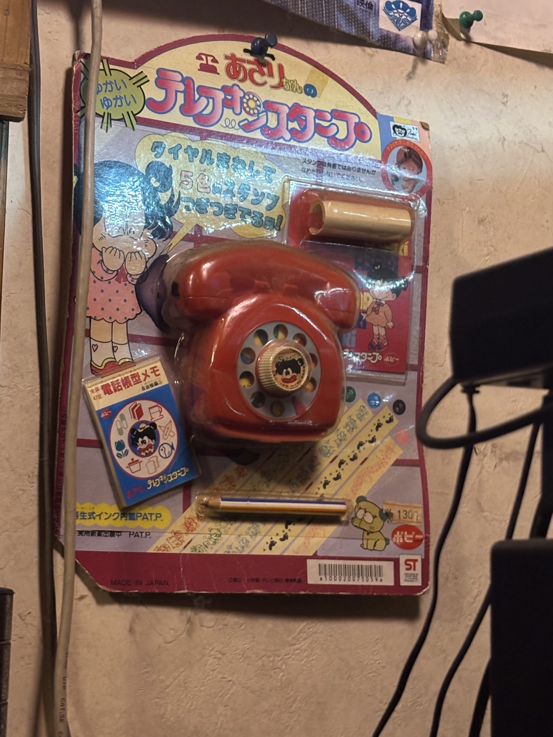 昭和のおもちゃ電話『テレフォンスタンプ』が壁に展示された様子