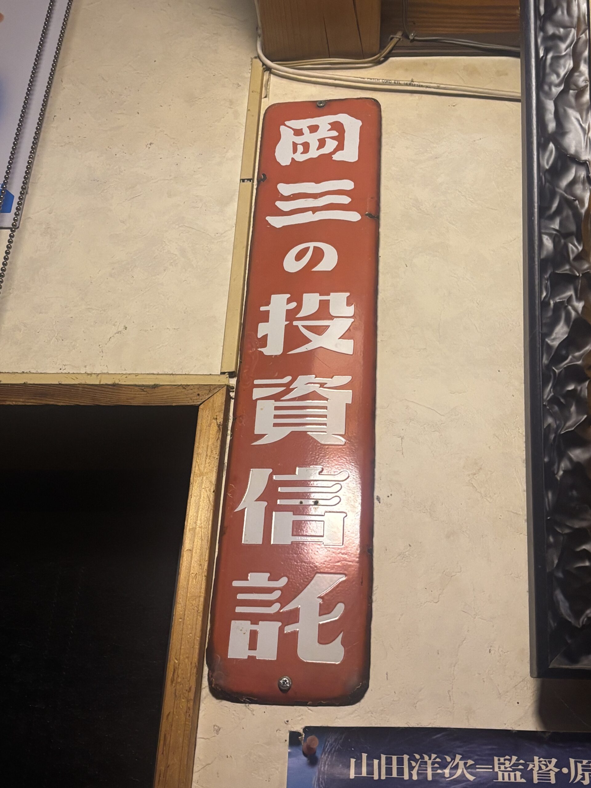 たっちゃんち店内に飾られた昭和レトロな岡三の投資信託の看板